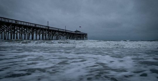 pier in the ocean with a dark sky